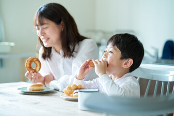 Obraz na płótnie Canvas ドーナツを食べる母親と息子
