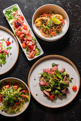 variety of restaurant food dishes on table. top view.