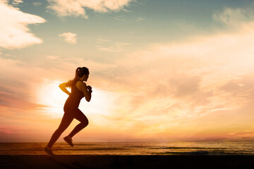 Fototapeta na wymiar Woman Running on the Beach at Sunset or sunset
