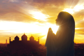 Silhouette of muslim woman having worship and praying for fasting