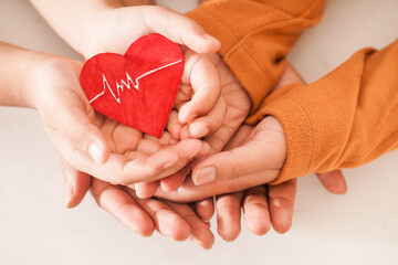 close up of family hand holding a heart symbol together