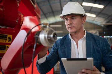 Robotics control engineers solve problems and setting programming of control robot arm in factory