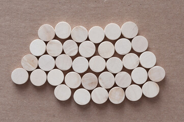 isolated bed of round wooden shapes on cardboard