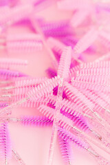 Mascara brushes isolated on pink background. Makeup pink brushes, makeup kits. Disposable brush for eyelashes and eyebrows. Close-up.