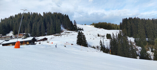Waidring, Austria - 15.01.2023: View of skiers and ski slope in ski resort Waidring, Tyrolean Alps, snowy chalet restaurant in background