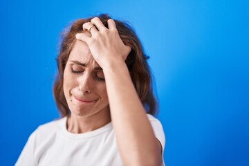 Young beautiful hispanic woman suffering for headache crying over isolated blue background