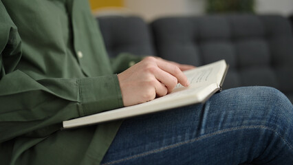 Young caucasian woman reading a book at home