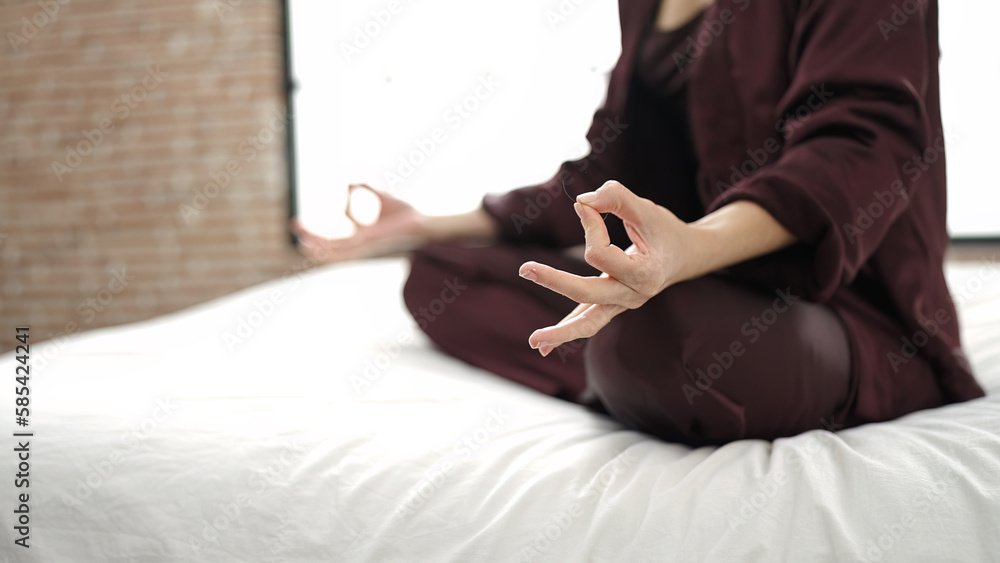 Poster Young caucasian woman doing yoga posture sitting on bed at bedroom