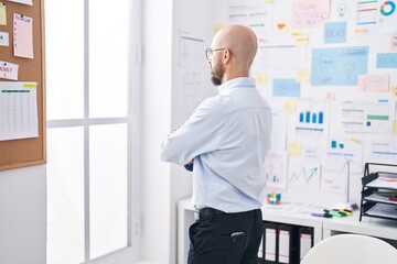 Young bald man business worker looking throw the window at office