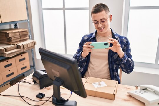 Young hispanic man ecommerce business worker make photo to package at office