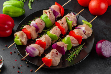 Cooking chicken shish kebab or shashlik. Raw chicken meat with vegetables, pepper and onion on...