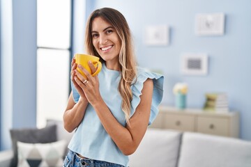 Young woman smiling confident drinking coffee at home