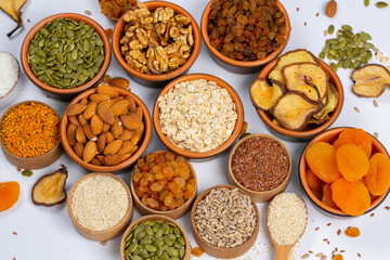 Healthy vegetarian food concept. Assortment of dried fruits, nuts and seeds on white background. Top view. Mixed nuts set closeup.