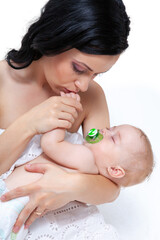 Obraz na płótnie Canvas baby as leep on hands of mother on a light background