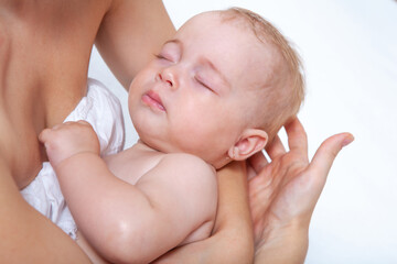 baby as leep on hands of mother on a light background