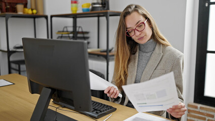 Young caucasian woman business worker using computer reading document at office