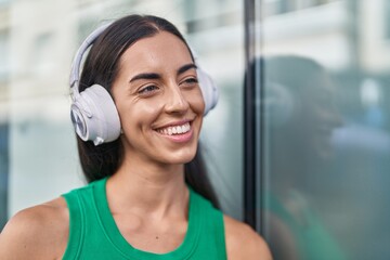 Young beautiful hispanic woman smiling confident listening to music at street