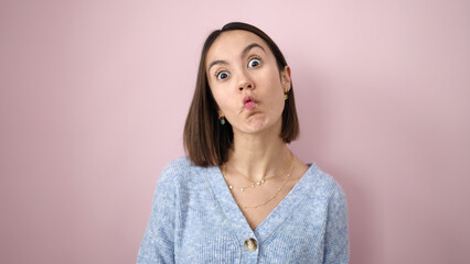 Fototapeta premium Young beautiful hispanic woman doing funny gesture with lips over isolated pink background