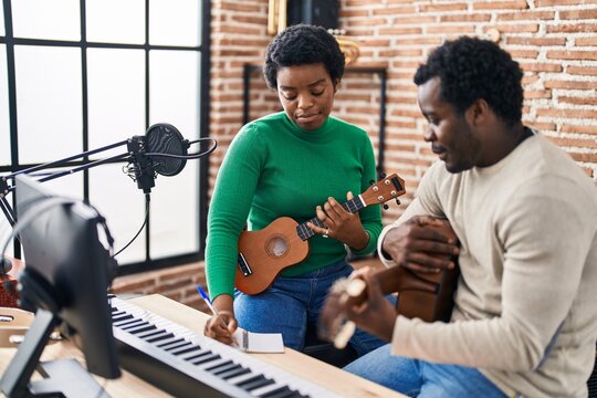 African american man and woman music group compising song at music studio