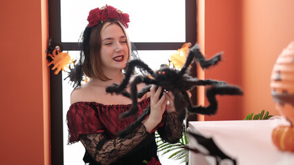 Young blonde woman wearing katrina costume decorating halloween party at home