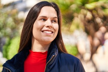 Young beautiful hispanic woman smiling confident looking to the side at park