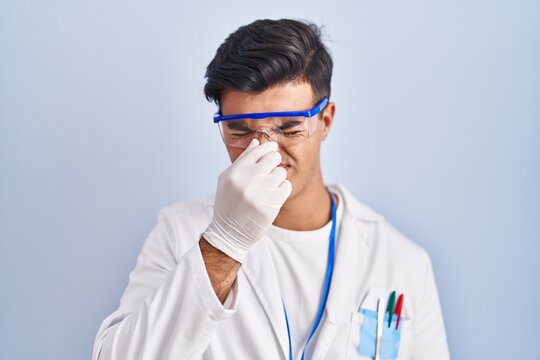 Hispanic Man Working As Scientist Tired Rubbing Nose And Eyes Feeling Fatigue And Headache. Stress And Frustration Concept.