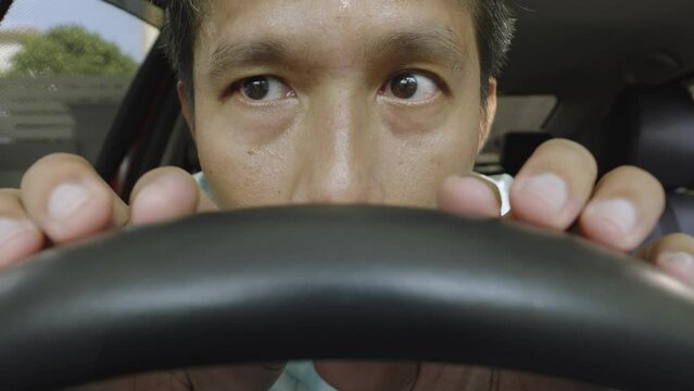 Asian man having problem, hiding or waiting someone in the car. Debt, adulterous, drug, gambling or break the law concept.