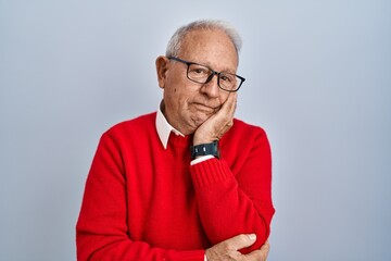 Senior man with grey hair standing over isolated background thinking looking tired and bored with depression problems with crossed arms.