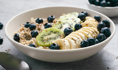 Oatmeal Bowl with Blueberry, Banana and Kiwi, Oat Porridge in a Bowl on Bright Background, Healthy Snack or Breakfast