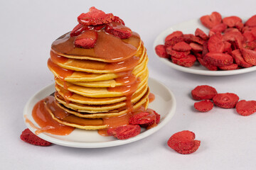 Pancakes with raspberries and caramel on a white plate