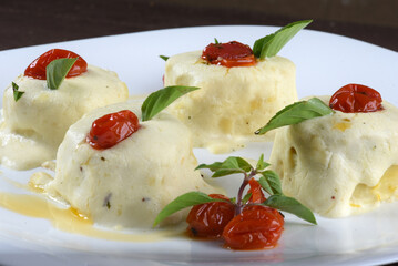italian food cannelloni pasta with white sauce and tomatoes