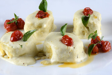 italian food cannelloni pasta with white sauce and tomatoes