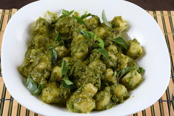 italian food potato gnocchi with basil pesto on white plate