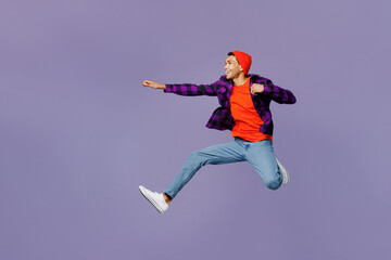 Fototapeta na wymiar Full body side view young man of African American ethnicity wear casual shirt orange hat jump high with outstretched hands pov have super power isolated on plain pastel purple color background studio