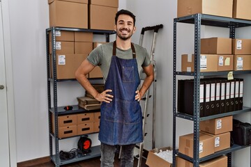 Young hispanic man business worker smiling confident standing at storehouse