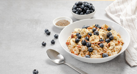 Oatmeal Bowl, Oat Porridge with Blueberry, Banana and Pecans in a Bowl on Bright Background, Healthy Snack or Breakfast