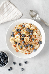 Oatmeal Bowl, Oat Porridge with Blueberry, Banana and Pecans in a Bowl on Bright Background, Healthy Snack or Breakfast