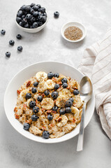Oatmeal Bowl, Oat Porridge with Blueberry, Banana and Pecans in a Bowl on Bright Background, Healthy Snack or Breakfast