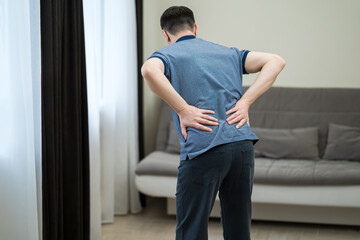 Back pain, kidney inflammation, man suffering from backache at home