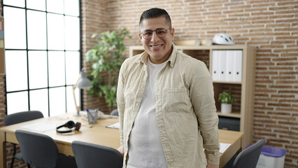 Young hispanic man business worker standing at office