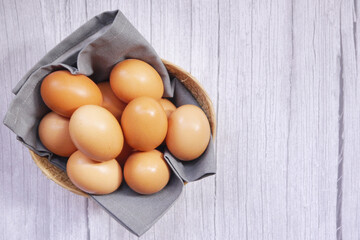 Basket of eggs on a wooden table.
