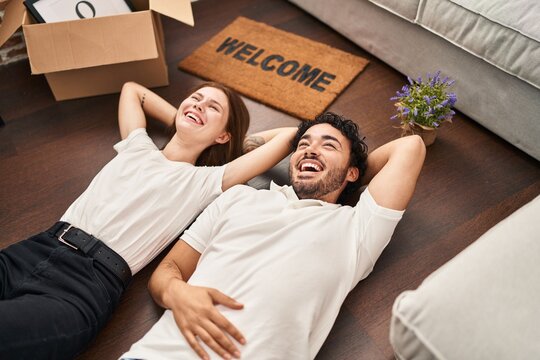Man and woman couple smiling confident lying on floor at new home - Powered by Adobe