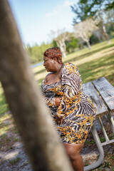 Woman posing in the park blocked by tree