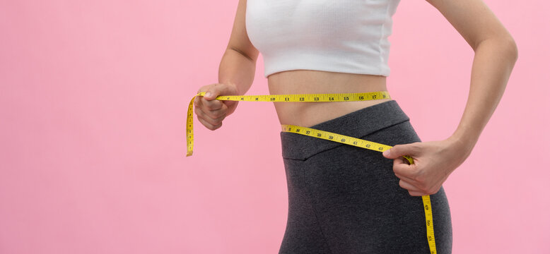 Diet and dieting. Beauty slim female body use tape measure. Woman in exercise clothes achieves weight loss goal for healthy life, crazy about thinness, thin waist, nutritionist..