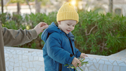 Caucasian toddler having fun playing with plants at park