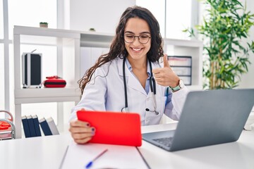 Young doctor woman working on online appointment smiling happy and positive, thumb up doing excellent and approval sign