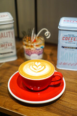 A red mug set of coffee, a cup of coffee, nicely pour rosetta latte art coffee on wooden background