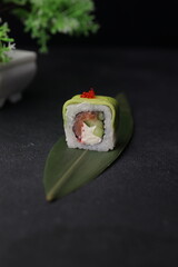 Sushi rolls on black background with salmon cheese and fish