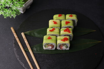 Sushi rolls on black background with salmon cheese and fish