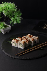 Sushi rolls on black background with salmon cheese and fish
